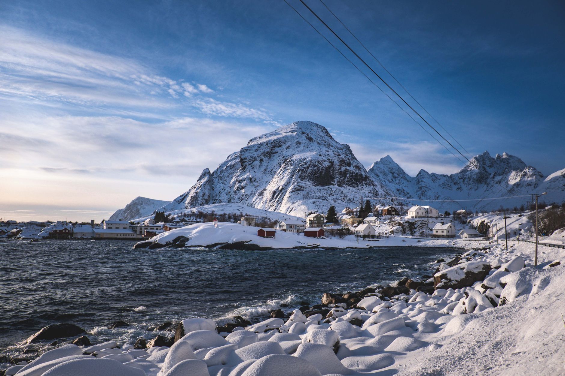 Panoramic view of Lofoten snowy peaks and wooden rorbu cabins